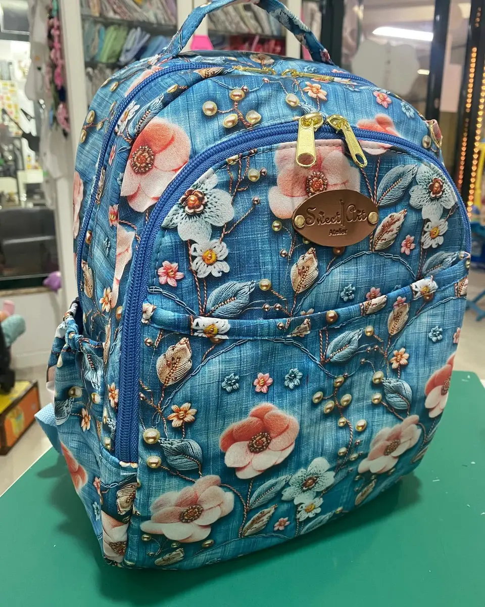 Mochila em tecido azul estampado com flores cor de pêssego.