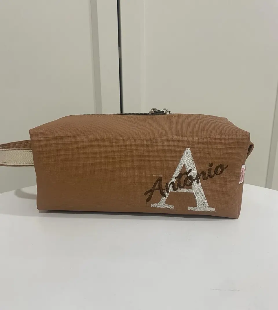 Necessaire castanha com a inicial A em branco e o nome António bordado.